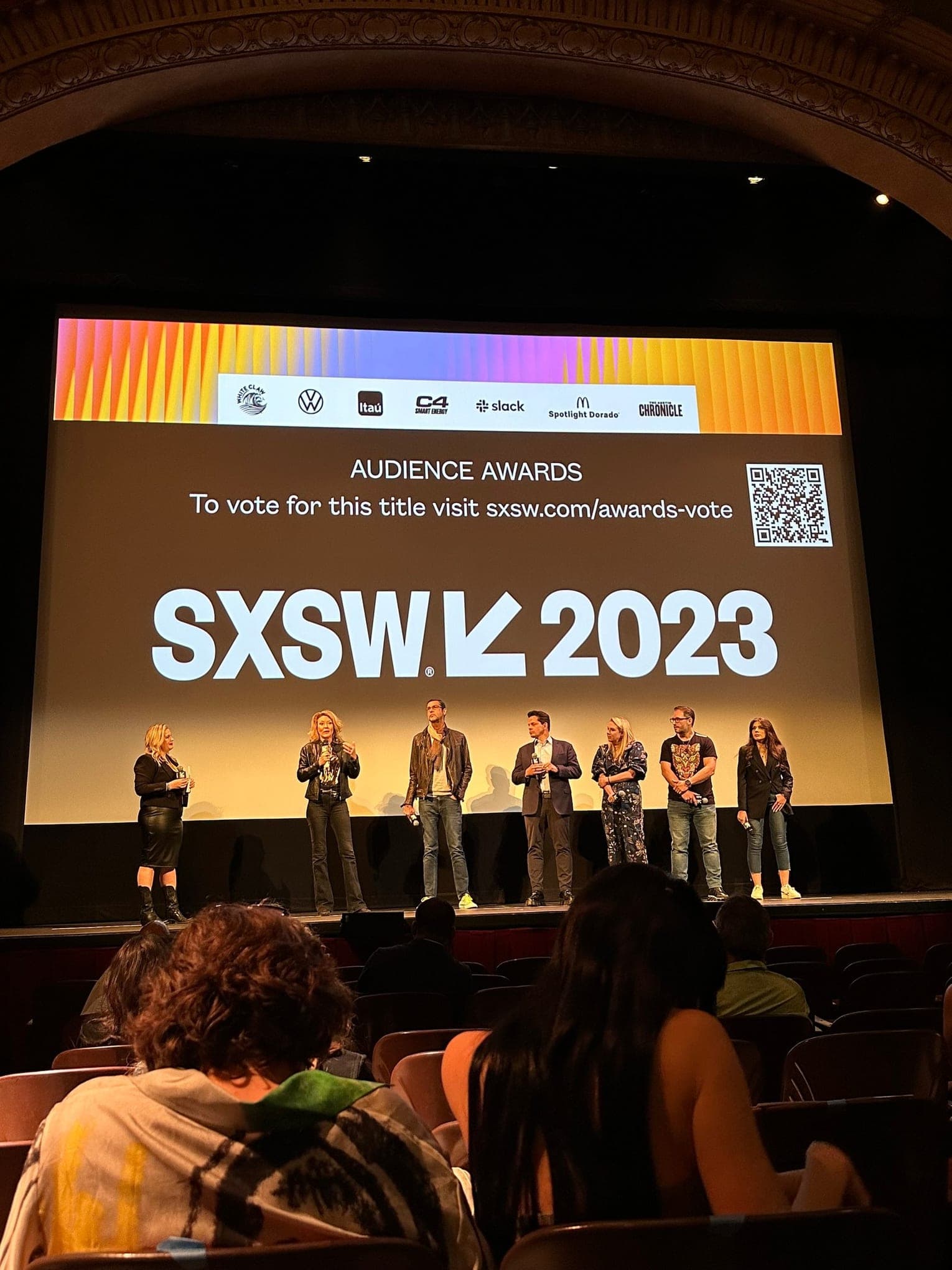 Taylor Price on stage at SXSW 2023 with six other speakers in front of a screen that reads Audience Awards and SXSW 2023.